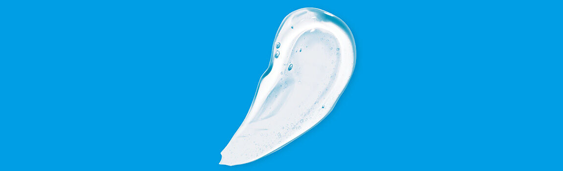 A smooth, translucent blob of a clear gel or lotion on a bright blue background.