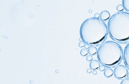 Close-up of transparent water bubbles against a light blue background.