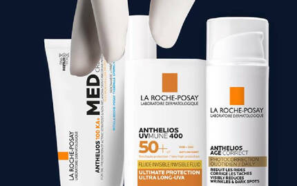 Trois produits de soin solaire de La Roche-Posay sur un fond sombre, y compris un tube de creme et deux flacons.