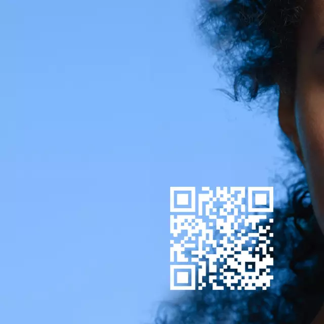 Une femme avec des cheveux frises regarde l'objectif, a cote d'un telephone affichant un visage numerique, avec un fond bleu et un code QR.
