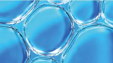 Close-up of transparent bubbles arranged against a light blue background, creating a textured and fluid appearance.