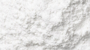 A close-up view of a soft, white powder with a slightly textured surface.