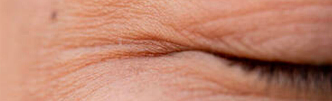 Close-up of a person's closed eyelid, showcasing fine lines and textures of the skin.
