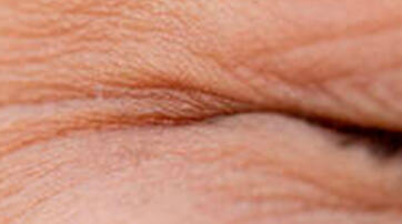 Close-up of a person's closed eyelid, showcasing fine lines and textures of the skin.