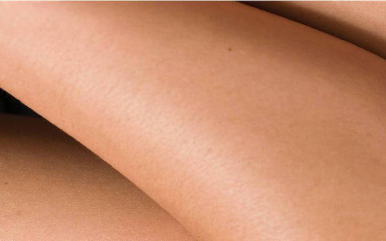Image representant des parties de jambes entremelees, mettant en valeur une peau douce et des courbes naturelles.