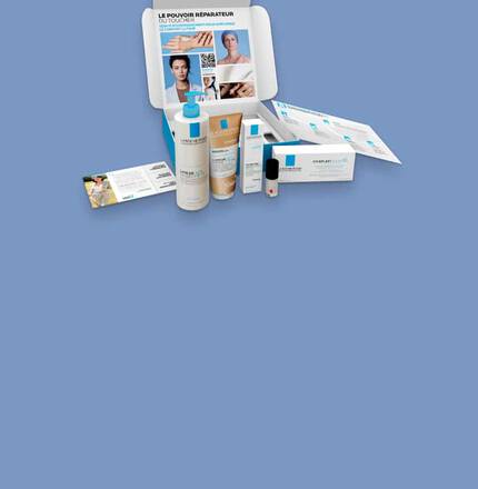 Un ensemble de produits de soins de la peau sur fond bleu, comprenant des flacons et des echantillons.