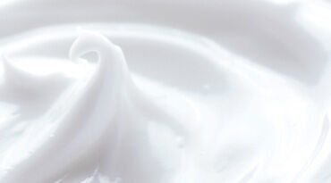 Close-up of smooth, creamy white substance, with a soft swirl texture.