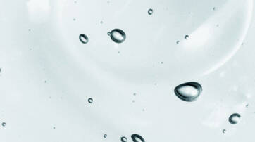 Close-up of water droplets suspended on a clear surface, creating a serene and soothing visual.