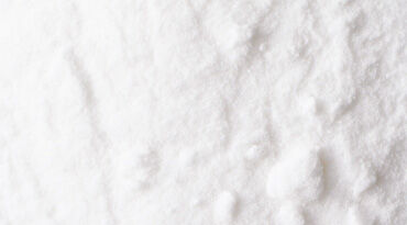 Close-up of white granulated substance with a textured surface.