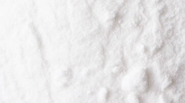 Close-up of white granulated substance with a textured surface.