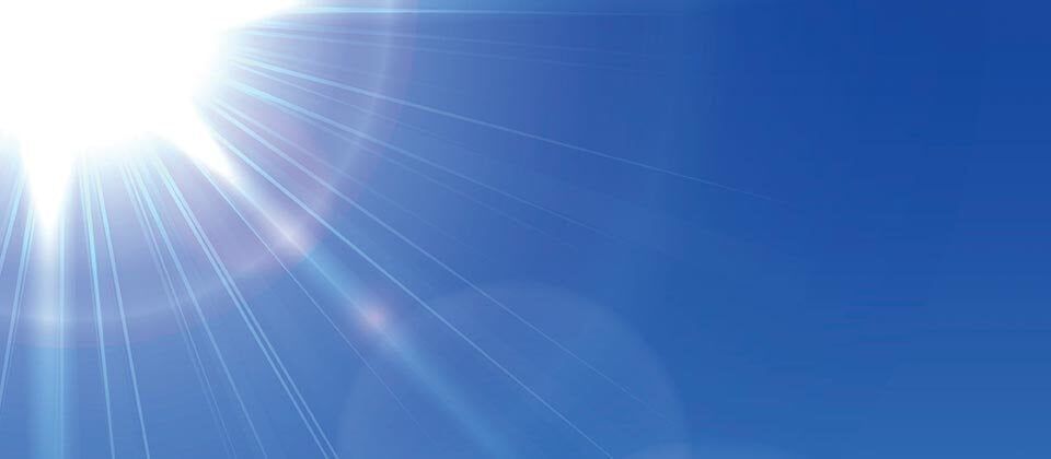 A bright sun shining in a blue sky, with rays of light radiating outward.
