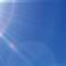 A bright sun shining in a blue sky, with rays of light radiating outward.