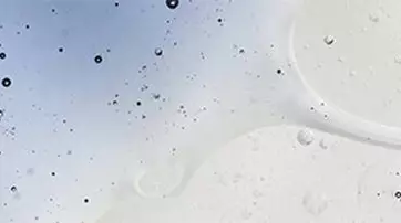 Abstract image featuring a light-colored background with bubbles and droplets scattered throughout.