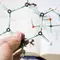 A person's hand holds a molecular model made of colored plastic sticks and balls, with a chemistry textbook open in the background.