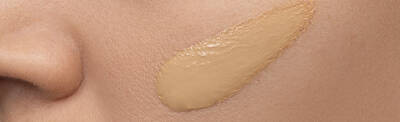 Close-up of a smooth application of foundation on skin, showcasing a natural skin tone.