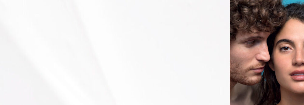 Un homme aux cheveux boucles se penche vers une femme aux cheveux longs, sur fond clair, avec un code QR sur le cote gauche.