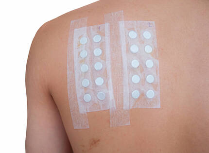 Bandages adhesifs sur le dos, contenant plusieurs pastilles blanches, numerotes 1 et 2.