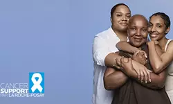 Trois femmes souriantes s'enlacant sur un fond bleu, avec le logo « Cancer Support par La Roche-Posay ».