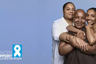 Trois femmes souriantes s'enlacant sur un fond bleu, avec le logo « Cancer Support par La Roche-Posay ».