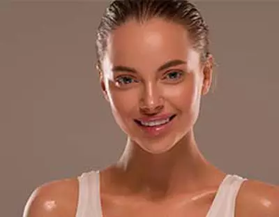 Une jeune femme souriante avec un teint lumineux, sur fond neutre.