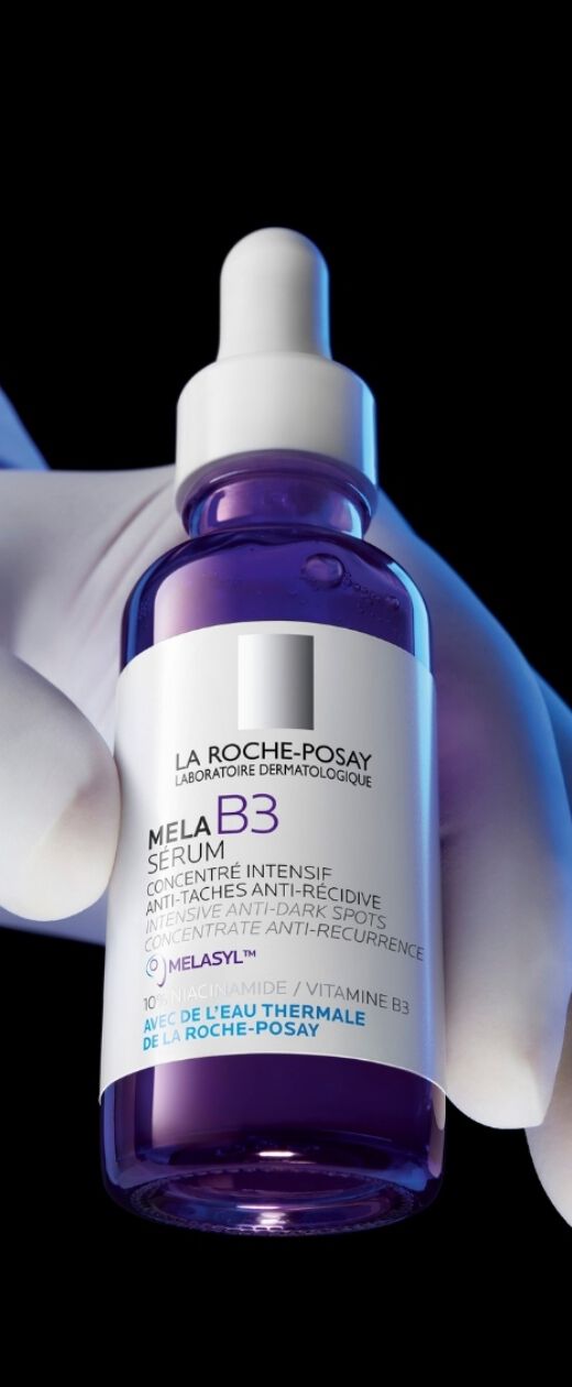 Un homme chuchote a une femme, leurs visages proches, exprimant intimite et connexion. Fond flou et minimaliste.