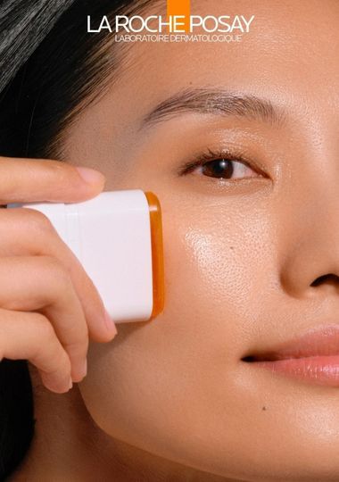 Une image montrant une comparaison du visage d'une femme, a gauche avec protection UV SPF 50+ et a droite sans protection UV, mettant en evidence les differences de vieillissement cutane.
