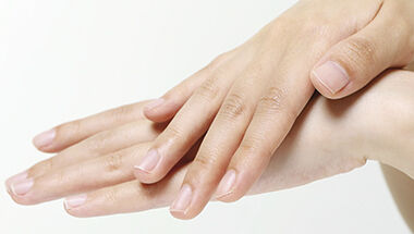 Gros plan sur des mains propres et soignees aux ongles naturels sur fond blanc.