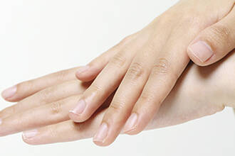 Gros plan sur des mains propres et soignees aux ongles naturels sur fond blanc.