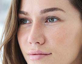 Femme avec des yeux clairs et un regard contemplatif.