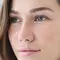 Femme avec des yeux clairs et un regard contemplatif.