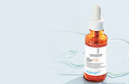 Flacon de serum avec pipette sur fond bleu clair.