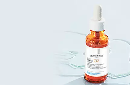 Flacon de serum avec pipette sur fond bleu clair.