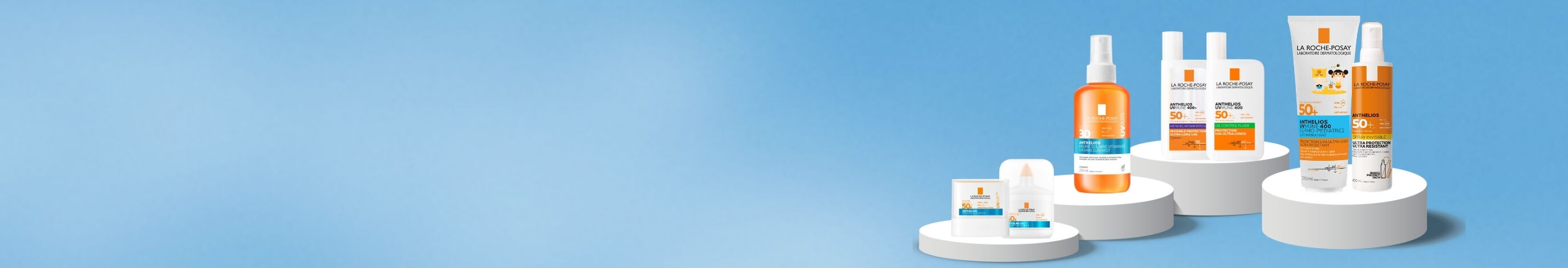 Gamme de produits de protection solaire, comprenant des flacons et un tube sur fond bleu clair.