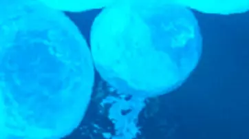 Deux spheres bleues lumineuses flottent dans un fond d'eau sombre.